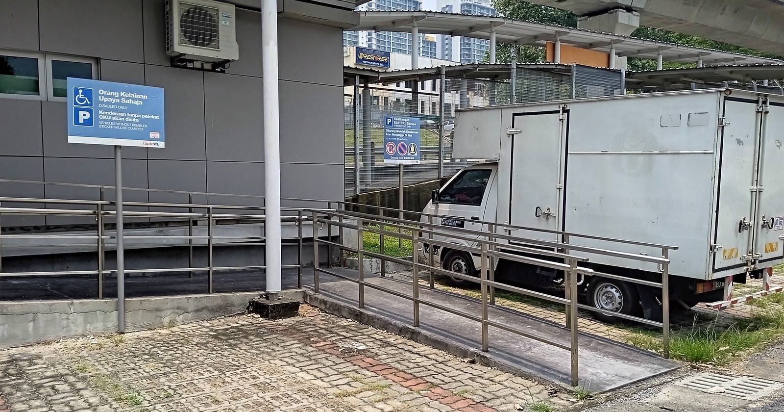 Podjazd dla wózków przy stacji kolei miejskiej — najprostszy obraz tego, że o uczestnictwie decyduje kształt otoczenia, a nie sprawność ciała.